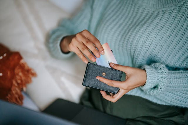 Person pulling card out of black wallet